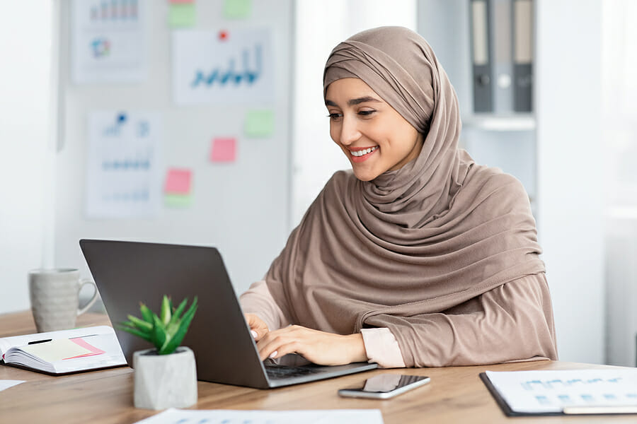 Office Job. Happy Islamic Woman In Hijab Working On Laptop At De