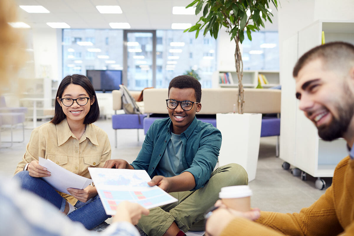 people sitting together smiling and handing papers